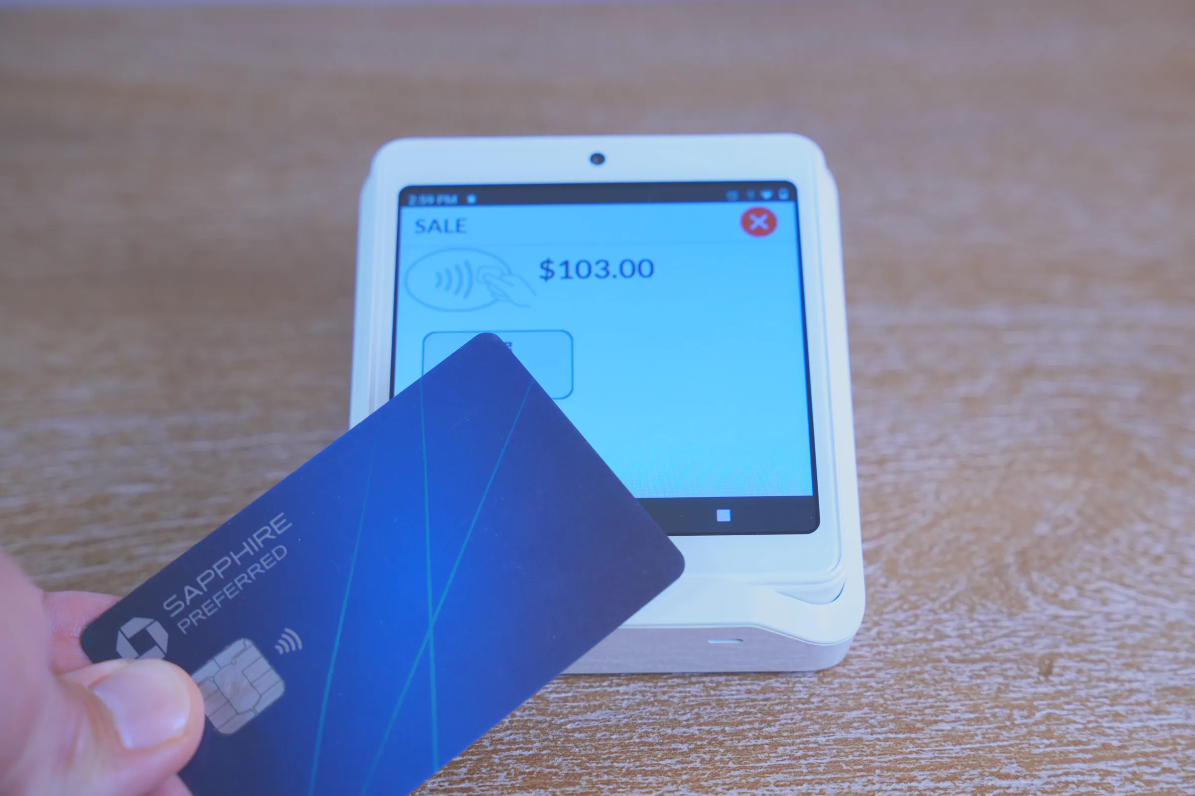 A patient taps a card on a Summit terminal that shows a $103.00 sale.